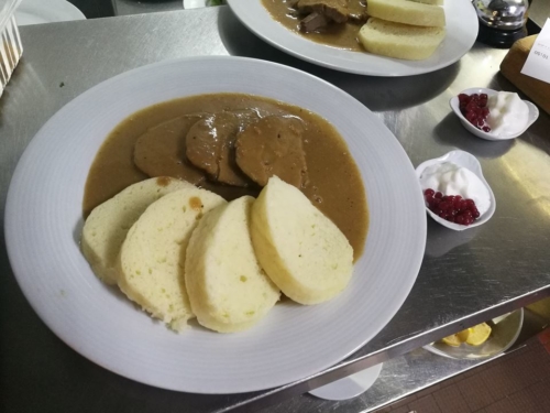 Svíčková, typical czech dish. Sirloin with creamy sauce and dumplings. Served with whipped cream and cranberries.